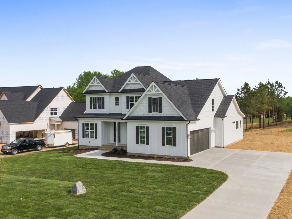 White modern farmhouse with a finished dark shingle roof